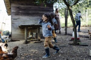 Family in a chicken pen on an organic farm